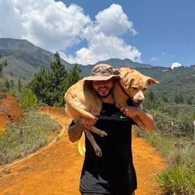 Joven cargando a su perro labrador después de una caminata, cuidando de sus pulpejos lesionados.